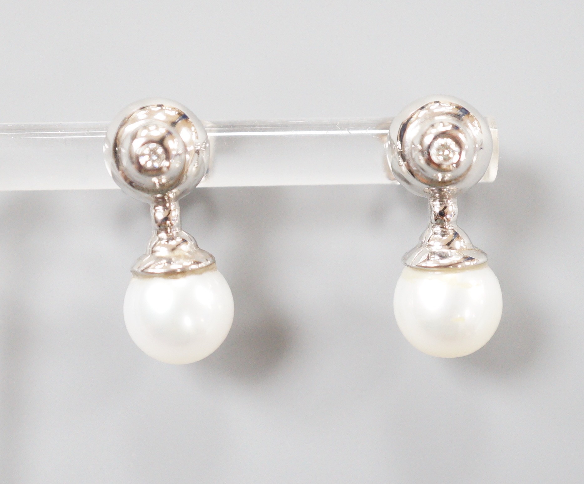 A modern pair of 198ct white gold cultured pearl and single stone collet set diamond ear studs, 19mm, gross weight 5.4 grams.